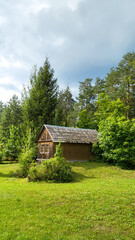 Typical traditional Lithuanian dwelling as a wooden house in with a road in summer with blue sky in Palūšė, Ignalina district, Lithuania