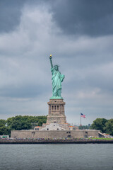 Statue of liberty on liberty island in New York with a cloudy sky