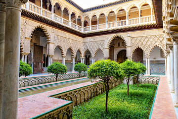 Fototapeta premium Beautiful formal public garden inside Alcazar Seville palace in summertime in Andalusia