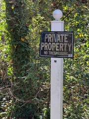 Private property no trespassing sign on a white post
