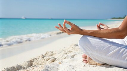 Close-up of a person meditating in the lotus position on a sandy tropical beach with turquoise water and a clear sky, promoting mindfulness, relaxation, and inner peace.