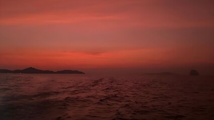 Fototapeta premium evening sunset sky with sun and clouds in red tones, silhouettes of birds flying over the water,Impressive View of Shiny Rising Sun,Cloudscape Nature Background.Sun set in west coast.