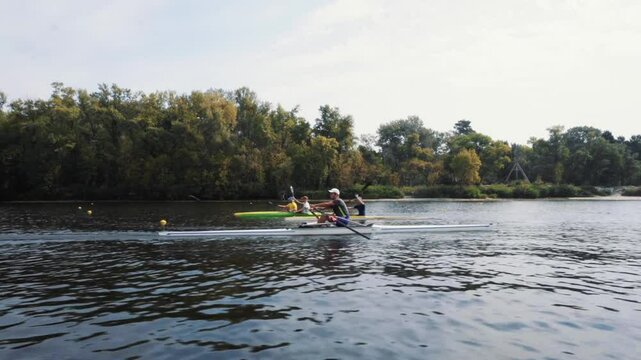 Young solo rower rows through a calm water in autumn, Kyiv, Ukraine. Caucasian man training a rowing boat. Man kayaking on a river autumn. Single one athlete rower in a boat on the river Dnipro.