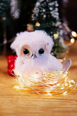 beautiful New Year's owl in a nest made of garland in a Christmas setting