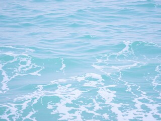 Obraz premium Pure blue turquoise water with gentle foam and waves, waves, water texture, turquoise