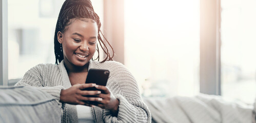 Phone, relax and smile with black woman on sofa in living room of home for communication or search. App, social media and text message with happy person in apartment on weekend for internet browsing