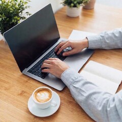 A high-resolution ultrarealistic image captures a modern, cozy workspace. The scene features a sleek laptop with a blank screen, positioned on a wooden desk. A person's hand is poised over the keyboar