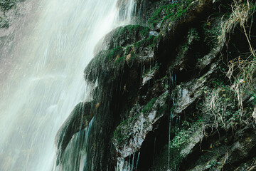 Mountain waterfall with green moss on the rocks