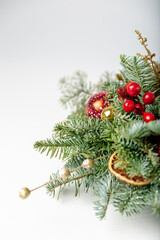 Decorated christmas tree with ornaments and lights, white background for festive holiday designs. Beautiful Christmas wreath decorated with pine cones, berries, red and golden balls