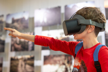 A young boy in augmented reality glasses explores an interactive museum exhibit, merging technology...