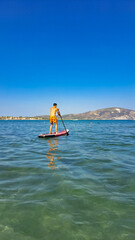 young man floats on a sub board on the sea