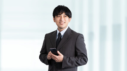 スマホを持つ笑顔の男性ビジネスマン
