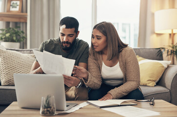 Sofa, couple and discussion with paperwork for finance, track expenses or planning for budget goals. Laptop, man and woman with bills notes for tax review, handle savings or mortgage document at home