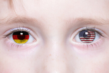 Naklejka premium human face with national flags of germany and united states of america in the eyes.