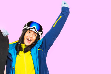 Young caucasian pretty woman model excited stand isolated hold snowboard pose hands up enjoy ski holidays preparation travel. Mock up skier by pink pastel wall background.Extreme outdoors weekend trip