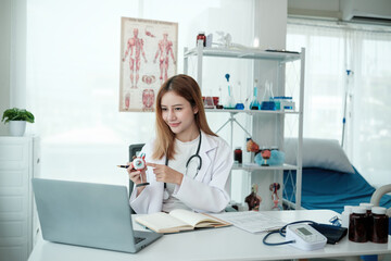 A woman doctor is pointing at a medical model on a laptop