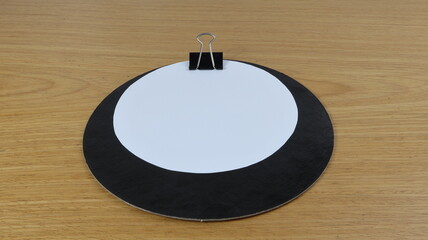 White sheet of paper with round shape on desk with wood color background