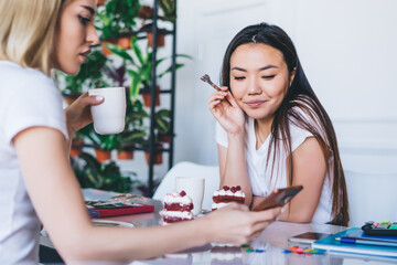 Young women texting on cellphone in creative workplace