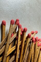  Close-up of several old matchsticks with red tips and sticks scattered across a smooth granite surface.
