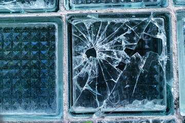 Broken glass with cracks and hole. Broken glass after gun shot. Cracked texture of broken glass with hole.