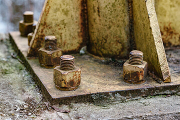 Steel bolt nut attaches the steel plate to the cement column. Rusty nut and washer on steel structure. corrosion of steel. bolt and nut on metal.