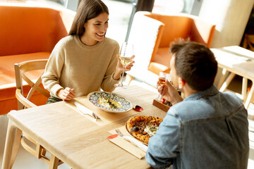 A joyful couple enjoying a delightful meal together at a cozy restaurant during a sunny afternoon