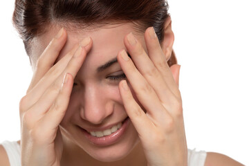 Fototapeta premium Portrait of yong happy ashamed woman, covering face with hands, beautiful model posing in studio over white background
