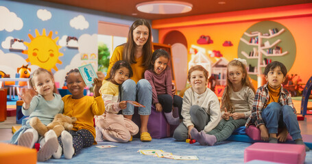 Portrait of Happy Diverse Children Posing Together with a Female Preschool Teacher in a Modern...