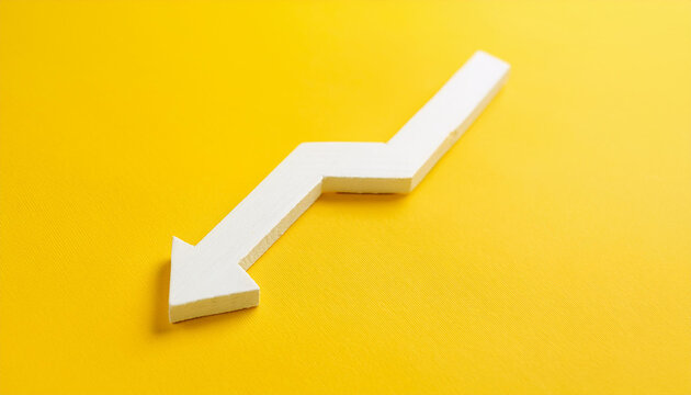 White wooden arrow pointing down on yellow background. Business, market decline or economic.