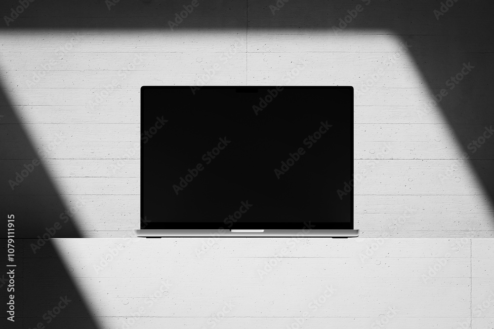 Wall mural scene with an open laptop with a blank screen on a concrete background