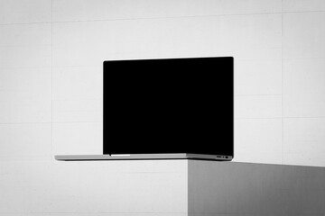 Scene with an open laptop with a blank screen on a concrete background