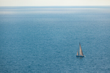 Regatta sailing ship yachts with white sails at opened sea. Aerial view of sailboat in windy...