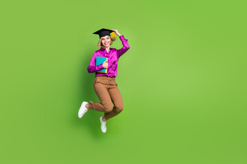 Full body portrait of nice young lady mortarboard hat book jump empty space wear shirt isolated on...
