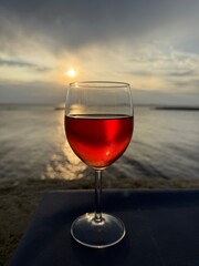 glass of red wine at sunset over the sea