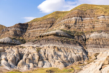 Canyon in badlands with eroded formations on the hills in summer.