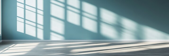 Obraz premium 青い壁の部屋に影を落とす窓の光が美しい午後の風景