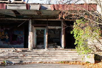 Abandoned building entrance with graffiti and weathered decay