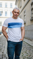 A man in a white shirt with blue stripes is standing on a cobblestone street. He has a serious expression on his face