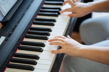 Obraz premium A highly skilled and talented pianist expertly plays a beautiful grand piano, producing a soothing and mesmerizing melody that captivates and enchants all who listen with great attention