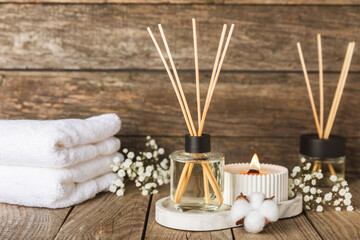 Aromatic reed air freshener on wooden table.Diffuser with natural fruity, floral, spicy aroma.interior scent. Luxury perfume for the home.Orange, lime, coffee, cinnamon, star anise, vanilla and orchid