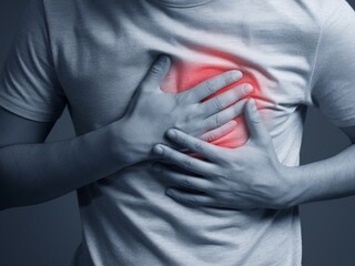 Man in Gray T-Shirt Holding Chest with Red Glow Highlighting Painful Area