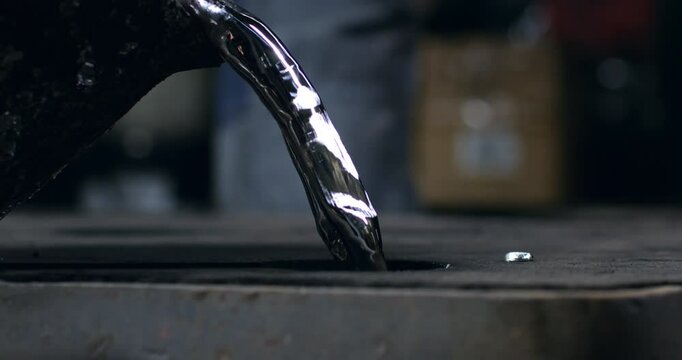 Super slow motion macro of aluminum metal foundry process in industrial factory, 1000 fps. Molten metal flows, splashes and hardens as it's poured into molds, showcasing precision and craftsmanship