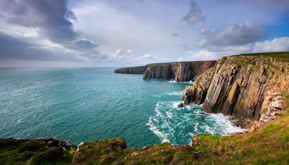 Obraz premium Waves Meet Cliffs: A Cloud-Covered Day in Pembrokeshire National Park
