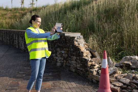 Insurance claims adjuster taking a photo and evaluating damage after incident