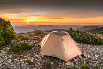 Tent Camping In The Mountains, First Morning Light. Campsite with a dome tent on a high mountain bluff at sunrise.Travel concept and background.