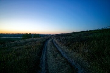 Dirt road through a field in the early morning