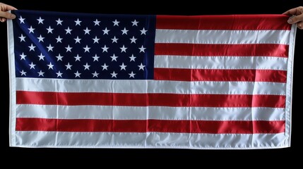 Fototapeta premium Two hands proudly hold an American flag against a dark backdrop, emphasizing its vibrant colors and iconic design, symbolizing freedom and national pride