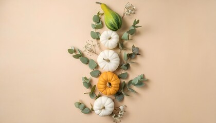 Thanksgiving fall background, garland of pumpkins and leaves on the middle of a beige background, top view, flat lay, copy space for text 