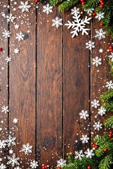 Fototapeta premium Empty wooden table top with frame made of snowflakes and fir tree branches. Background for design for winter holidays, Christmas and New Year. Top view, flat lay with copy space