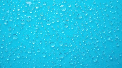 Water drops glistening on a vibrant blue background, tranquil, refreshing, shiny